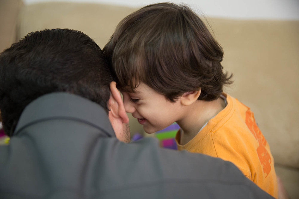 Abdel Malak, 4, wispers in his father's ear while playing. The family fled to Egypt 2,5 years ago. Because he is the youngest, Abdel Malak suffers much less from trauma than his two siblings.
