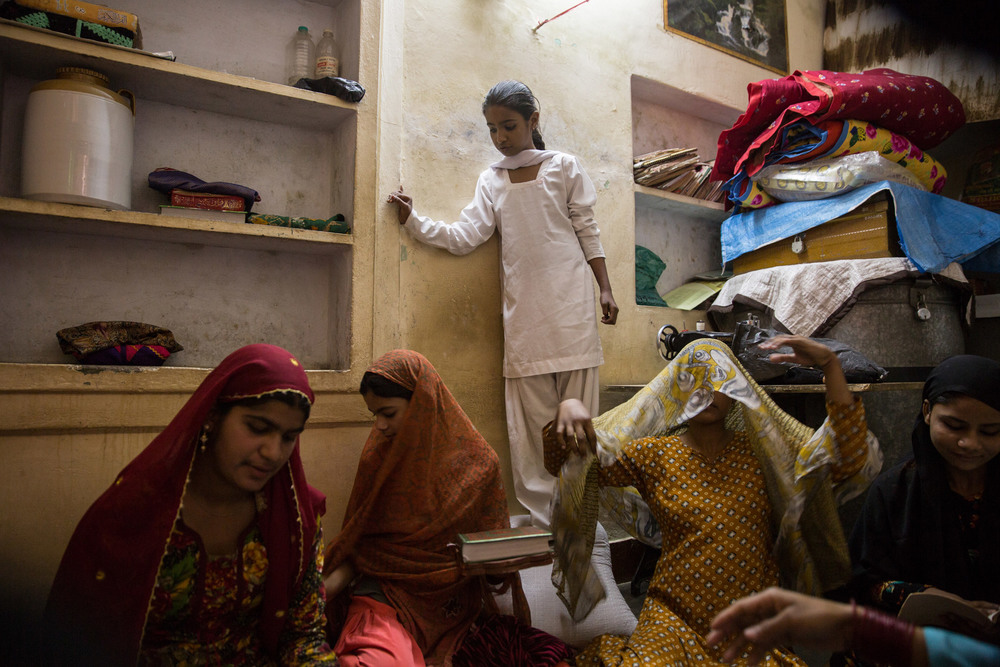 Girls gather around to recite the Quran in their daily after-school religious lesson. Half of the residents in Hasanpura are of the Muslim faith.