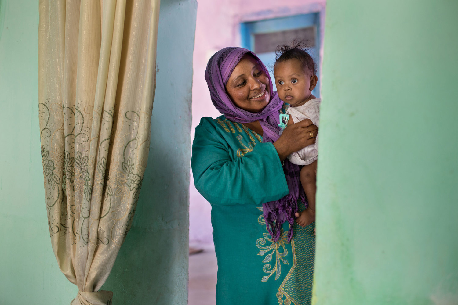  On Heisa Island, Sabreen holds her 6-month old son Mohammed. 