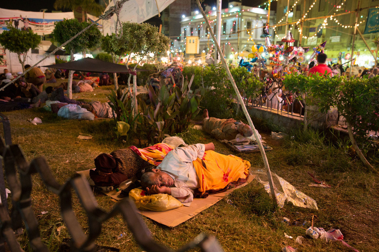  An elderly couple sleeps in a small park surrounded by the Sayeda Zeinab moulid festivities. The festival brings thousands of people from all over the country who often live and sleep in the neighborhood streets during the entire festival. 